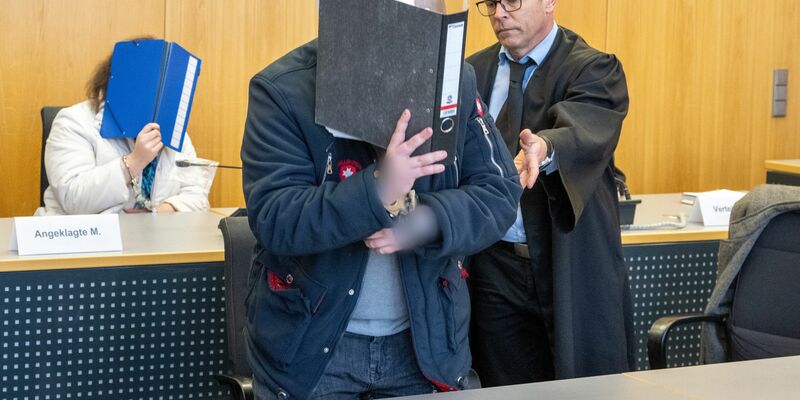 Im Landgericht weist ein Verteidiger seinem Klienten seinen Platz auf der Anklagebank. Dieser musste sich gemeinsam mit seiner Partnerin wegen Mordes verantworten. - Foto: Stefan Puchner/dpa