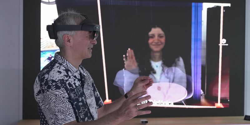 O2-Innovationsmanager Karsten Erlebach spricht via VR-Brille mit seiner Kollegin, die er in der Brille plastisch als Hologramm sieht. - Foto: Barbaros Bulgurcu/o2 Telefonica/dpa