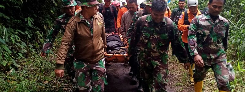 Rettungskräfte tragen einen verletzten Bergsteiger in der Nähe des Vulkans Marapi auf der indonesischen Insel Sumatra. - Foto: Givo Alputra/AP/dpa