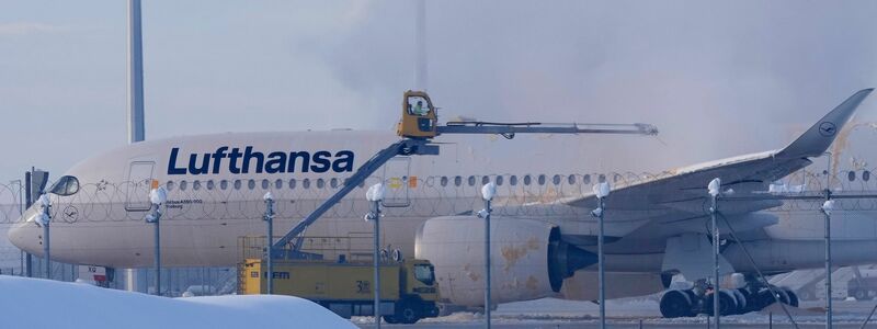Ein Flugzeug der Lufthansa wird auf dem Flughafen München enteist. - Foto: Matthias Schrader/AP/dpa