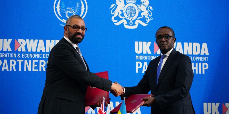 Großbritanniens Innenminister James Cleverly (l) und Vincent Birut, Außenminister von Ruanda, schütteln sich die Hände. Mit dem neuen Vertrag will die britische Regierung Asylsuchende künftig in das ostafrikanische Land abschieben. - Foto: Ben Birchall/Pool PA/AP/dpa