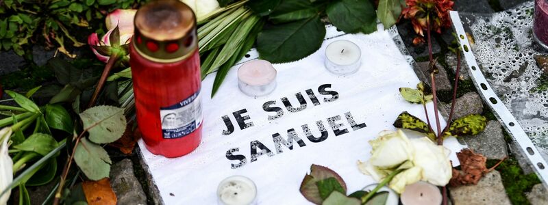 Blumen, Kerzen und ein Stück Papier mit der Aufschrift «Je suis Samuel». (Archivbild) - Foto: Kira Hofmann/dpa