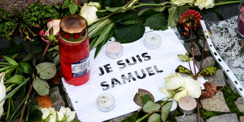 Blumen, Kerzen und ein Stück Papier mit der Aufschrift «Je suis Samuel». (Archivbild) - Foto: Kira Hofmann/dpa