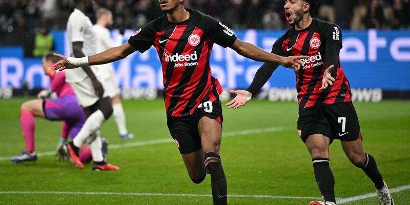 Abreibung für die Tuchel-Elf: Frankfurts Ansgar Knauff (l) und Omar Marmoush jubeln über das 5:1. - Foto: Arne Dedert/dpa