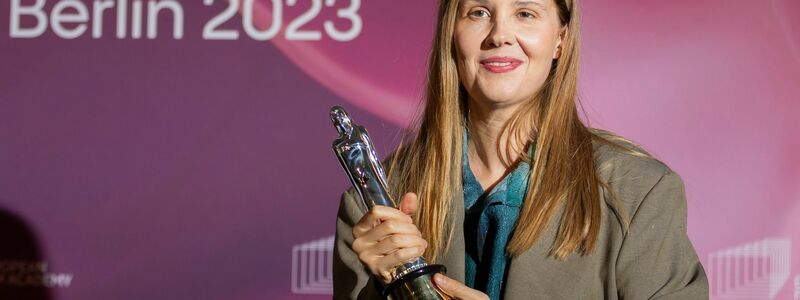 Justine Triet hält den Drehbuchpreis in ihren Händen. - Foto: Christoph Soeder/dpa