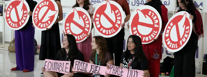 Aktivistinnen fordern in Dubai den Ausstieg aus fossilen Brennstoffen. - Foto: Peter Dejong/AP/dpa