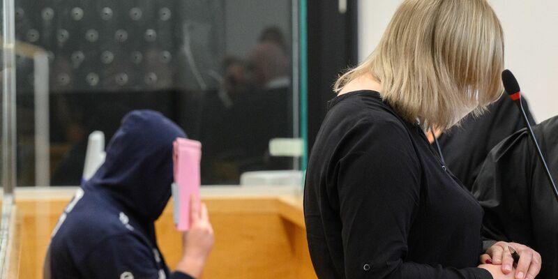 Die angeklagte Mutter und ihr Lebensgefährte warten im Gerichtsaal. - Foto: Julian Stratenschulte/dpa