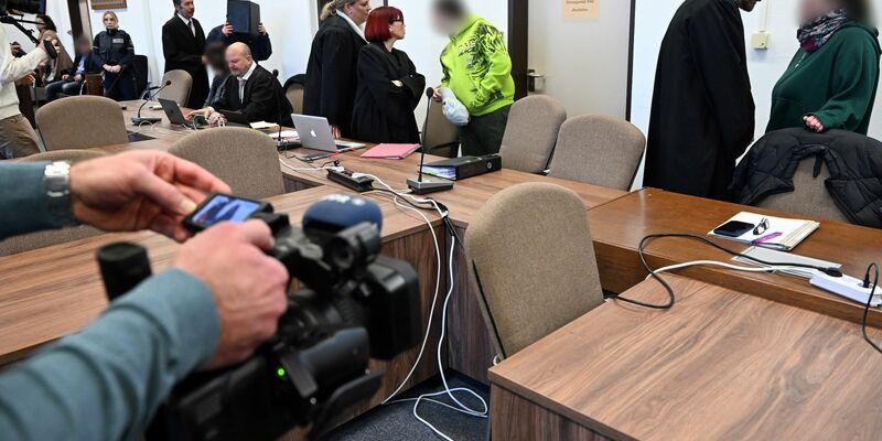 Die Angeklagten warten mit ihren Rechtsanwälten auf den Beginn des Prozesses in Köln. - Foto: Federico Gambarini/dpa