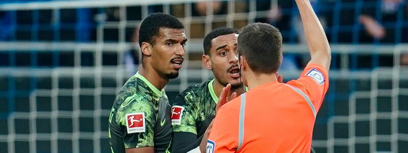 Schiedsrichter Robert Hartmann (r) zeigt Wolfsburgs Maxence Lacroix (M) in der 
27. Minute die rote Karte. - Foto: Uwe Anspach/dpa