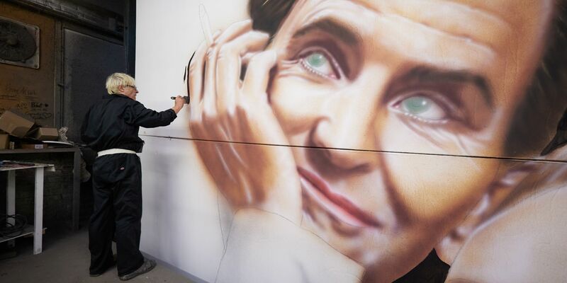 Mit dem gedruckten Original-Plakat als Vorlage malt Valien das Kinoplakat. - Foto: Jörg Carstensen/dpa