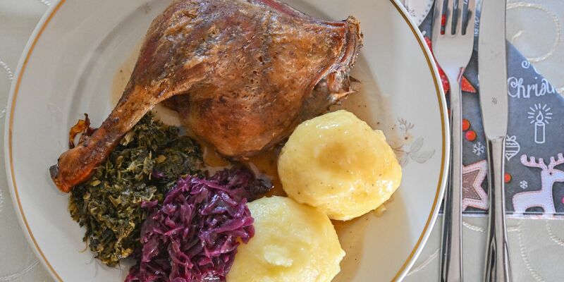 Das Weihnachtsessen nicht in Gefahr: Eine Entenkeule mit Klößen, Rotkohl und Grünkohl wird serviert. - Foto: Patrick Pleul/dpa