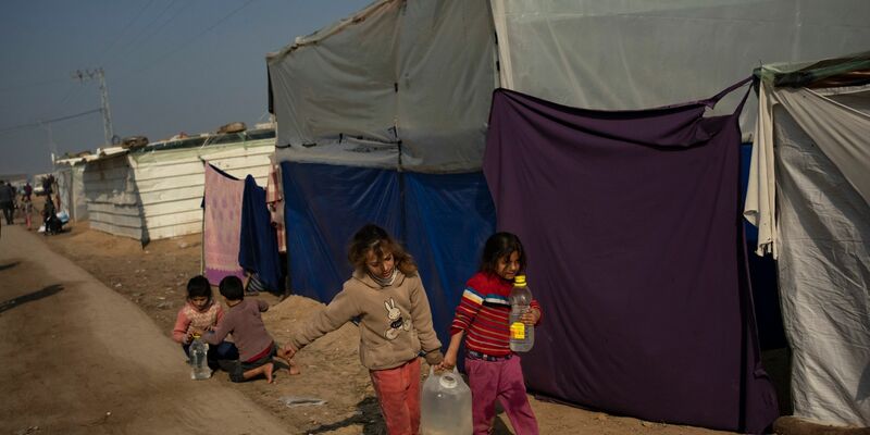 Palästinensische Kinder tragen Wasser in einem behelfsmäßigen Zeltlager. - Foto: Fatima Shbair/AP/dpa