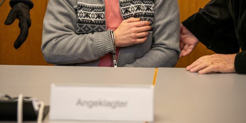 Mit Handschellen gefesselt sitzt der Angeklagte im Ulmer Landgericht. - Foto: Stefan Puchner/dpa