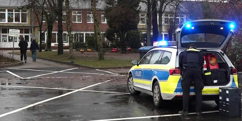 Ein Polizeiauto steht vor dem Gebäude einer Grund- und Hauptschule in Lüdingworth. Dort hat ein Mädchen ein anderes mit einem Messer schwer verletzt. - Foto: -/Nord-West-Media TV/dpa