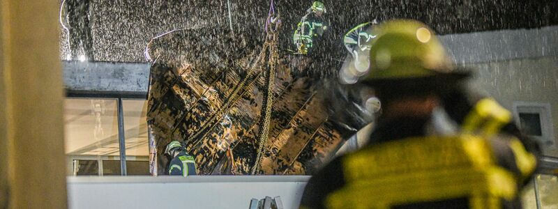 Einsatzkräfte der Feuerwehr sichern in Plüderhausen bei Stuttgart ein Teil des Daches ihres Feuerwehrhauses mit einem Kran. Zuvor hatte Sturntief «Zoltan» Teile des Daches abgedeckt. - Foto: Jason Tschepljakow/dpa