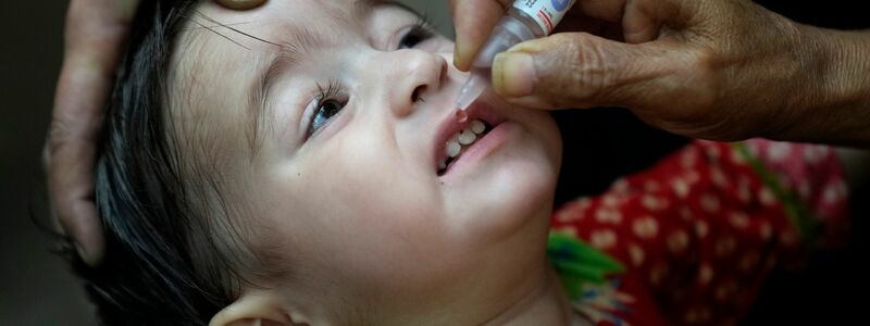 Ein Gesundheitshelfer verabreicht einem Kind einen Polio-Impfstoff. - Foto: K.M. Chaudary/AP/dpa