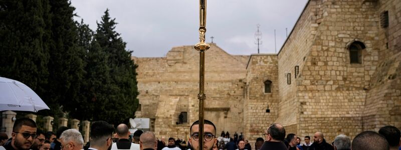 Katholische Geistliche gehen am Heiligabend in Bethlehem im Westjordanland in einer Prozession neben der Geburtskirche. - Foto: Leo Correa/AP/dpa