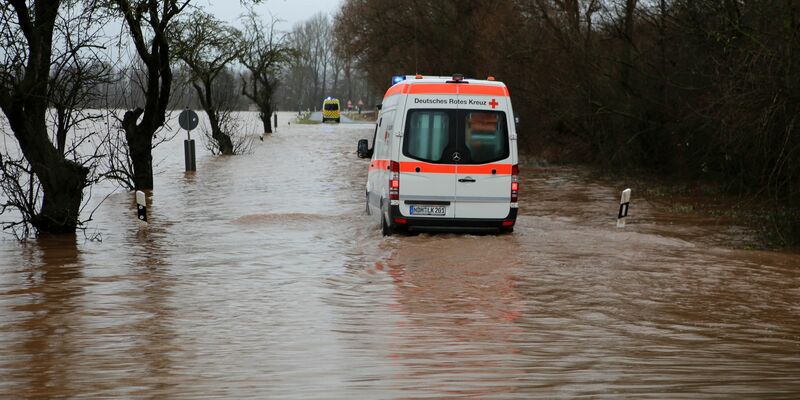 Ein Krankenwagen fährt über eine von Hochwasser überflutete Straße nach Windehausen in Thüringen. - Foto: Stefan Rampfel/dpa