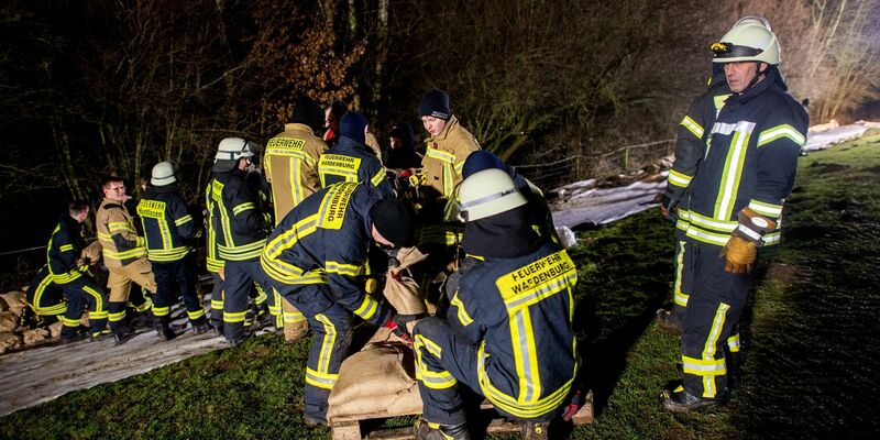 Einsatzkräfte der Feuerwehr sichern den aufgeweichten Deich der Hunte nahe der Ortschaft Astrup mit Vlies und Sandsäcken. - Foto: Hauke-Christian Dittrich/dpa