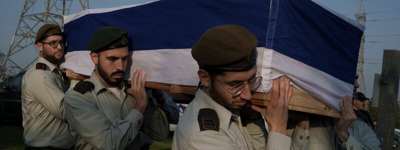 Israelische Soldaten tragen den Sarg eines Hauptmanns bei seiner Beerdigung auf einem Friedhof außerhalb von Aschkelon. - Foto: Leo Correa/AP/dpa
