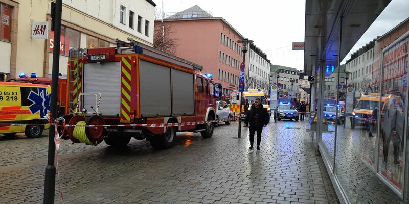 Einsatzkräfte von Feuerwehr und Rettungsdienst stehen am Freitag in der Innenstadt am Einsatzort. - Foto: -/Zema Medien/dpa