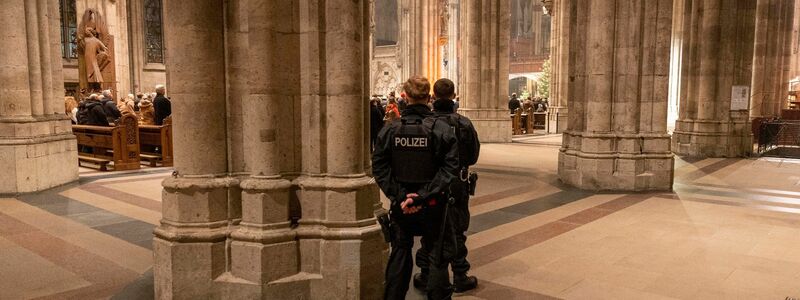Polizeibeamte sichern während der Silvester-Messe den Kölner Dom. - Foto: Thomas Banneyer/dpa