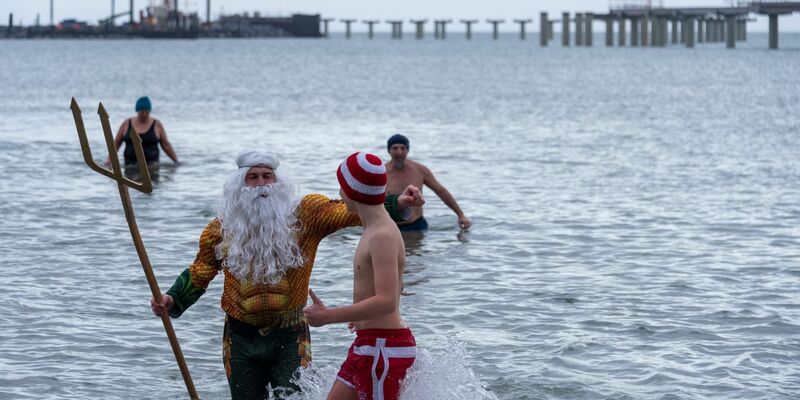 Als Neptun verkleidet steigt Tim Bergelt zusammen mit anderen Hobbyschwimmern aus dem 5 Grad kalten Meer, hier die Ostsee. - Foto: Stephan Schulz/dpa