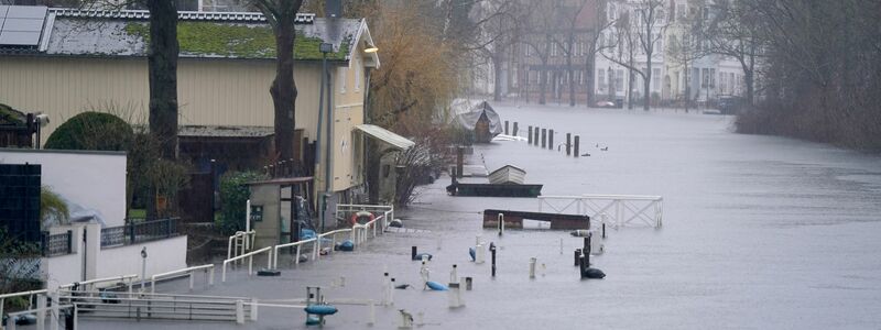 Gehwege und Bootsstege sind am Ufer der Trave in Lübeck vom Hochwasser umgeben. - Foto: Marcus Brandt/dpa