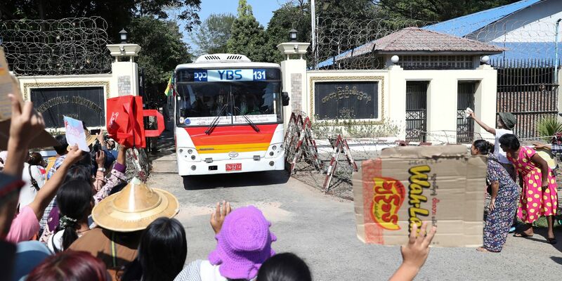Familienmitglieder und Freunde von Häftlingen stehen vor dem Insein-Gefängnis in Yangon, als ein Bus mit Freigelassenen vom Gelände fährt. - Foto: Thein Zaw/AP/dpa