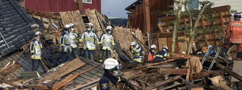 Rettungskräfte arbeiten an einem eingestürzten Gebäude in Wajima. - Foto: -/kyodo/dpa