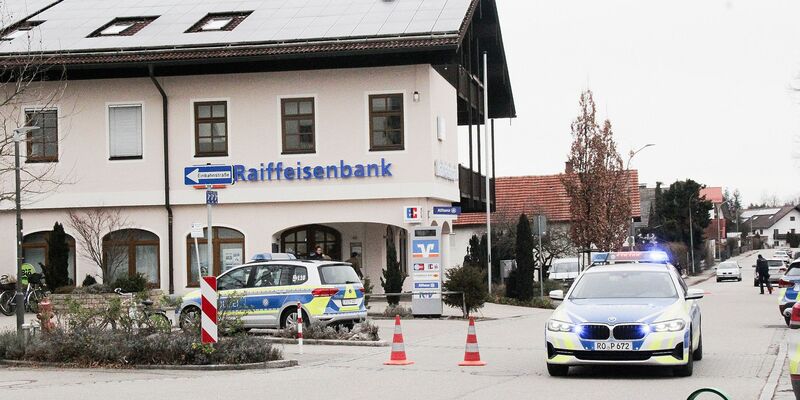 Einsatzkräfte der Polizei nach dem Überfall auf einen Geldtransporter in der Nähe einer Bank in Großkarolinenfeld in Bayern. - Foto: Josef Reisner/dpa