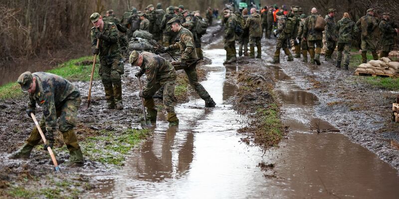 Soldatinnen und Soldaten der Bundeswehr sichern einen Deich an der Helme mit Sandsäcken. - Foto: Jan Woitas/dpa