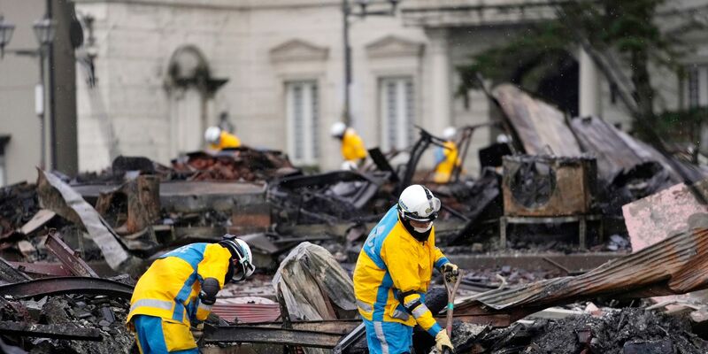 Polizeibeamte suchen nordwestlich von Tokio nach Opfern eines durch das Erdbeben verursachten Brandes. - Foto: Hiro Komae/AP