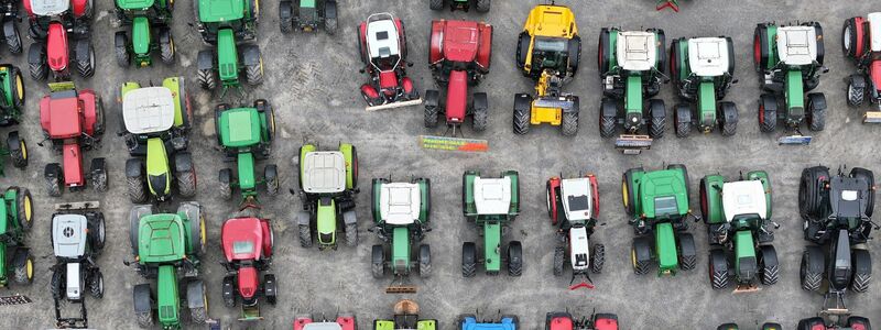 Bauern haben ihre Traktoren in Ravensburg auf einem Platz vor der Oberschwabenhalle abgestellt. - Foto: Felix Kästle/dpa