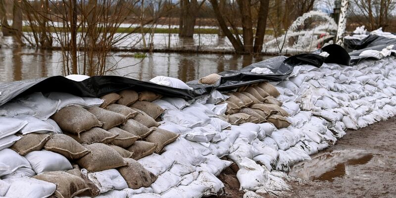 Einen großen Damm aus Sandsäcken haben freiwillige Helfer und Feuerwehren in den letzten Tagen an der Helme errichtet. - Foto: Heiko Rebsch/dpa