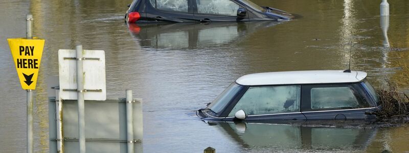 Autos auf einem überfluteten Parkplatz im britischen Wallingford. - Foto: Andrew Matthews/PA Wire/dpa