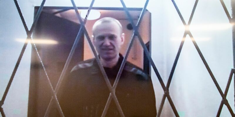 Alexej Nawalny ist auf einem Fernsehbildschirm zu sehen, als er per Video aus einem Gerichtssaal erscheint. - Foto: Antonina Favorskaya/AP/dpa