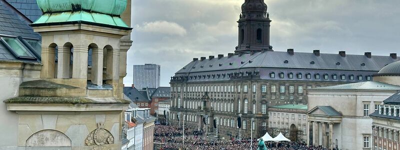 Menschen versammeln sich auf dem Platz von Schloss Christiansborg. - Foto: Steffen Trumpf/dpa