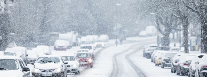 Nur langsam kommen Autos in der Kölner Innenstadt im dichten Schneetreiben voran. - Foto: Rolf Vennenbernd/dpa