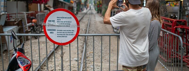 Zwei Touristen aus Brasilien fotografieren die abgesperrte «Train Street» in Hanoi. - Foto: Chris Humphrey/dpa