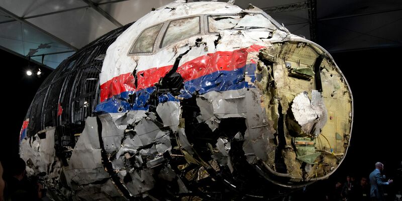 Die aus Trümmern teilweise wieder zusammengesetzte Boeing 777 der Malaysia Airlines, die als Flug MH17 über der Ukraine abgeschossen wurde, steht in einer Halle in Gilze-Rijen in den Niederlanden. - Foto: Peter Dejong/AP/dpa