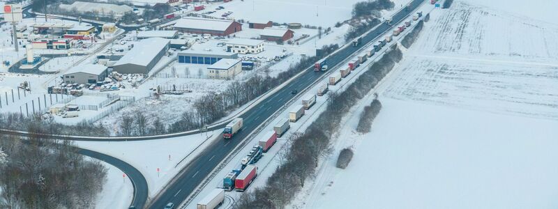LKW auf der Autobahn A5 Richtung Norden stehen bei Schnee und Eis im Stau. - Foto: Stefan Weber/Fuldamedia/dpa