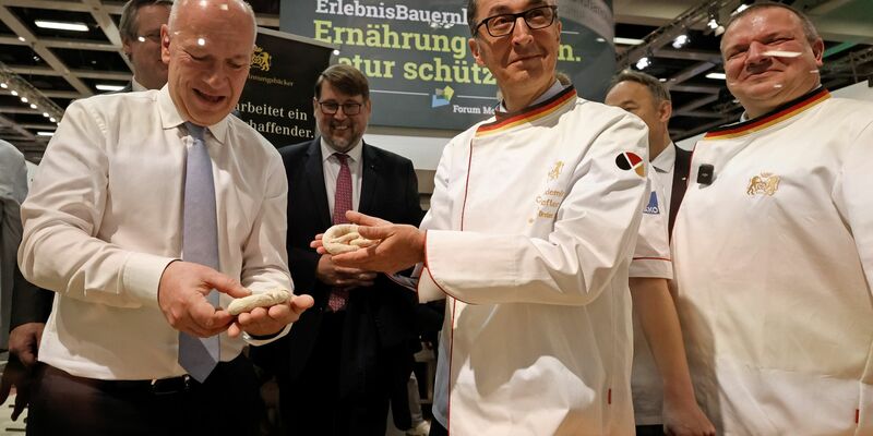 Bundesagrarminister Cem Özdemir und Berlins Regierender Bürgermeister Kai Wegner formen Brezeln beim Eröffnungsrundgang über das Messegelände der Grünen Woche. - Foto: Carsten Koall/dpa