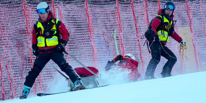 Petra Vlhova wird nach ihrem Sturz mit einem Schlitten von Rettungshelfern ins Tal gebracht. - Foto: Pier Marco Tacca/AP/dpa