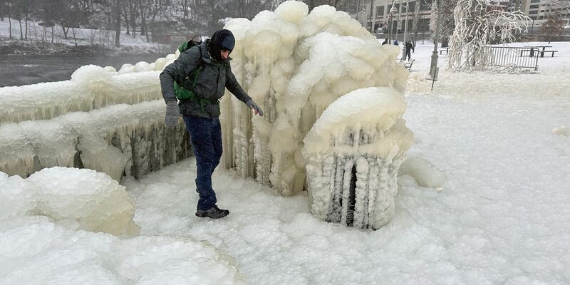 Unweit der Great-Falls-Wasserfälle von Paterson im US-Bundesstaat New Jersey geht ein Mann über eine dicke Eisschcht. - Foto: Ted Shaffrey/AP/dpa