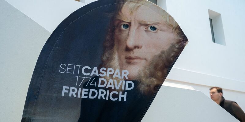 Ein Aufsteller mit einem Porträtbild von Caspar David Friedrich steht im Greifswalder Landesmuseum. - Foto: Stefan Sauer/dpa