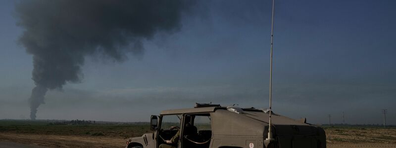 Israelische Soldaten in der Nähe der Grenze zwischen Israel und dem Gazastreifen, während in dem Küstengebiet Rauch in den Himmel steigt. - Foto: Leo Correa/AP/dpa