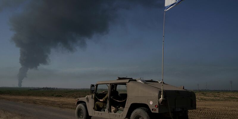 Israelische Soldaten in der Nähe der Grenze zwischen Israel und dem Gazastreifen, während in dem Küstengebiet Rauch in den Himmel steigt. - Foto: Leo Correa/AP/dpa