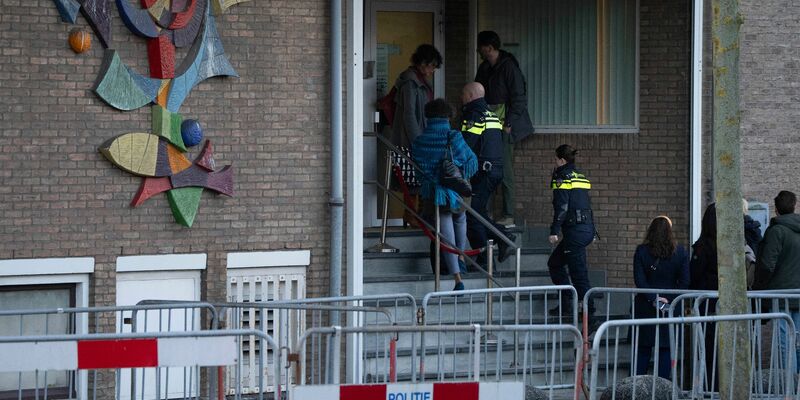 Zwei niederländische Polizeibeamte betreten das Hochsicherheitsgebäude des Gerichts. - Foto: Peter Dejong/AP/dpa