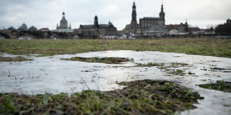 Die Elbwiesen gegenüber der historischen Dresdner Altstadtkulisse sind vom letzten Hochwasser gefroren. - Foto: Robert Michael/dpa